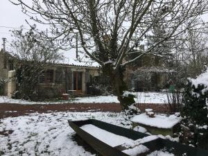 einen schneebedeckten Hof vor einem Haus in der Unterkunft Dormir Ben Aise Hammam Massages in Maillezais