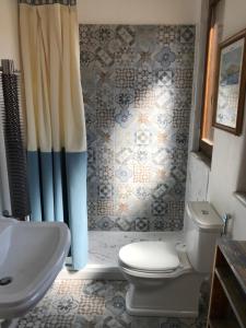 a bathroom with a toilet and a sink and a shower at Casetta di Lele in Palermo