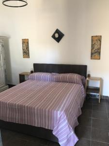 een slaapkamer met een bed met een paars gestreepte sprei bij Casetta di Lele in Palermo