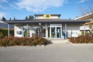 a white building with a yellow sign on top of it at Premiere Classe Avignon Parc Des Expositions in Montfavet