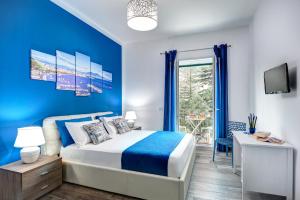 een blauwe slaapkamer met een bed en een raam bij I colori di Sorrento in Sorrento
