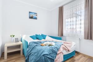 a bedroom with a blue bed with a stuffed animal on it at Elite Apartments Family City Center in Gdańsk