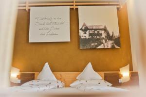 メラーノにあるHotel Villa Freiheimの壁に写真2枚が飾られた客室内のベッド2台