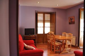 Una sala de estar con una mesa y un comedor. en Aparthotel Santa Marina, en Cuéllar
