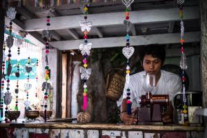 a man standing behind a counter with a machine at The Bodhi Tree Karimunjawa in Karimunjawa