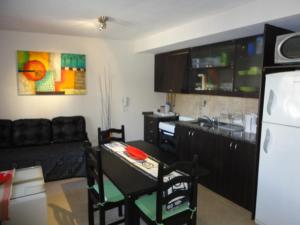 a kitchen with a table and a kitchen with a refrigerator at Complejo Temporario Las Marias in San Juan