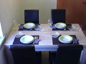 a table with chairs and plates and wine glasses at Ferienwohnung Ritha in Sandberg