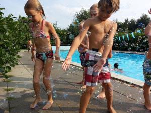 a group of children playing in the water at a swimming pool at Camping Gorishoek in Scherpenisse