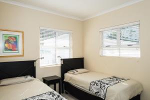 a bedroom with two beds and two windows at Long Island 42 in Ballito