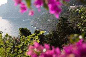 a view of the amalfi coast with pink flowers at Villa Mariuccia Capri in Capri