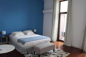 niebieska sypialnia z łóżkiem i oknem w obiekcie OHH - Porto Boutique Guest House w Porto