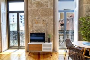 a living room with a tv and a table with chairs at Formosa 178 by Guestify in Porto +25 photos
