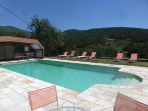a swimming pool with chairs and a table at Can Mahola in Beuda