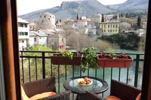 a table with a bowl of fruit on a balcony at Pansion Villa Nur in Mostar