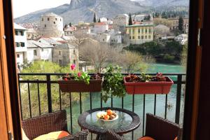 a balcony with a table and a view of a city at Pansion Villa Nur in Mostar