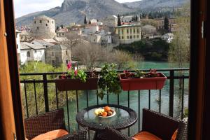 a table with a bowl of fruit on a balcony at Pansion Villa Nur in Mostar