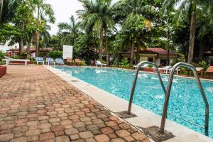 a swimming pool at a resort with chairs and trees at Shikara Beach Resort in Cavelossim