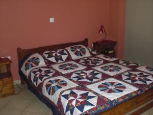 a bed with a quilt on it in a bedroom at Vegera Apartment M in Vasilikiádhes