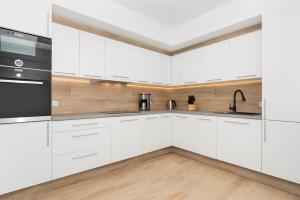 a kitchen with white cabinets and a sink at Holiday House Nemo by Renters in Międzywodzie