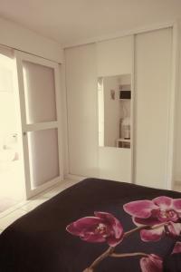 アルジェレス・シュル・メールにあるAppartement Annie LLENSEのベッドルーム1室(ピンクの花が咲くベッド付)