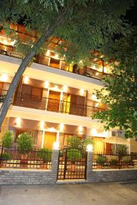 a large white building with a lit up facade at Vaya Apartments & Studios in Platamonas