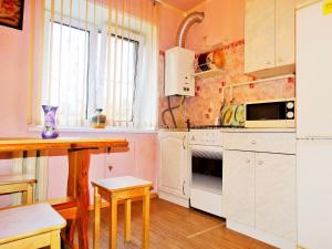 トゥーラにあるInndays on Dm. Ulaynova (эконом)の白いキャビネットとテーブル付きのキッチンが備わります。
