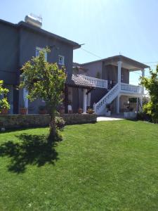 una casa con un césped verde delante de ella en Garden Rooms en Pírgos Psilonérou