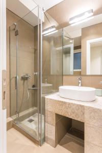 uma casa de banho com um lavatório e uma cabina de duche em vidro. em HiEnd 4th floor 1bdr em Atenas
