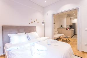 um quarto branco com uma cama grande e uma sala de estar em HiEnd 4th floor 1bdr em Atenas