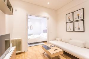 uma sala de estar com um sofá branco e um espelho em HiEnd 4th floor 1bdr em Atenas