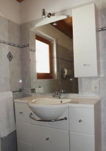 uma casa de banho com um lavatório e um espelho em Ferienwohnungen Auhaus em Martello