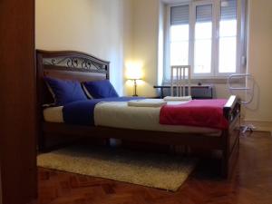 a bedroom with a large bed with blue and red sheets at Voyage 63 in Lisbon