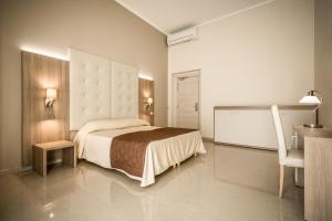 ジェノヴァにあるHotel Bel Soggiornoのベッドルーム1室(ベッド1台、デスク、椅子付)