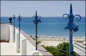 een rij straatverlichting naast een strand bij Cèsar in Vilanova i la Geltrú