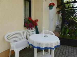 two white chairs and a table on a patio at Landpension Zum Schweizerberg in Neugrimnitz