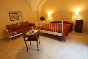 a bedroom with a bed and a couch and a table at B&B Ippocastano in Casarano