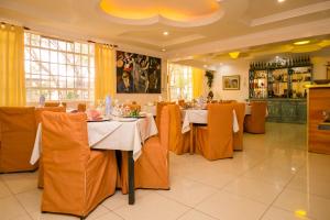 uma sala de jantar com mesas e cadeiras num restaurante em Hotel Rudi em Nairobi