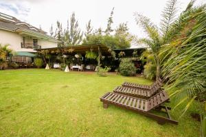 un patio con dos bancos frente a una casa en Hotel Rudi, en Nairobi