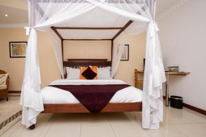 um quarto com uma cama de dossel e cortinas brancas em Hotel Rudi em Nairobi