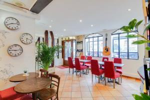 a restaurant with tables and chairs and clocks on the wall at Le Village Montmartre in Paris