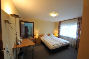 una habitación de hotel con una cama y un escritorio en Landhaus Schaaf, en Runkel