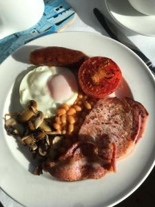 ein Frühstücksteller mit Eiern, Speck und Bohnen in der Unterkunft Honeycombe House in Mevagissey