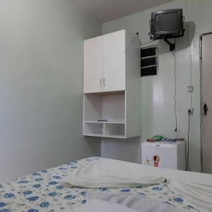 - une chambre avec un lit et une télévision murale dans l'établissement Pousada Ipojuca, à Caruaru