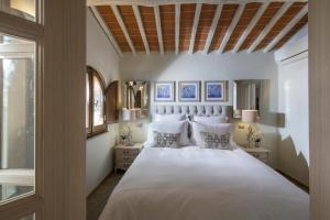 a bedroom with a large bed with white sheets and pillows at Borgo Argiano in Castelnuovo Berardenga