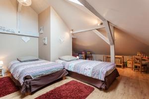 twee bedden in een kamer met een zolder bij La Rose Trémière in Wintzenheim-Kochersberg