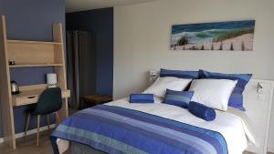 Schlafzimmer mit einem Bett mit blauen Wänden und einem Schreibtisch in der Unterkunft La Grange du Born in Sainte-Eulalie-en-Born