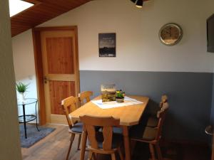 a dining room with a wooden table and chairs at Staller Hof inkl. Chiemgaukarte in Ruhpolding +12 photos