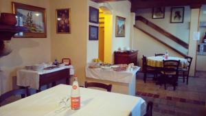 una sala da pranzo con due tavoli e sedie e un tavolo con una bottiglia di Corte Pioppazza a Ceresara