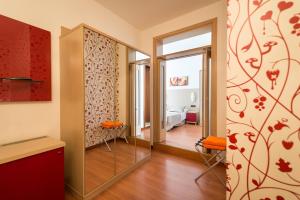 a hallway with a mirror and a room with a bedroom at Hotel Villa Angelina in Bibione