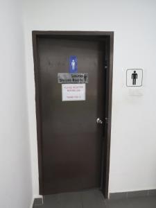 a brown elevator door with a sign on it at The Garden By J&G Vacation Homes in Skudai